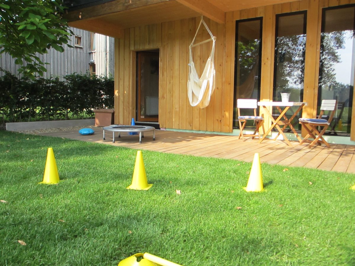 Garten hinter der Praxis mit Übungshütchen auf dem Rasen